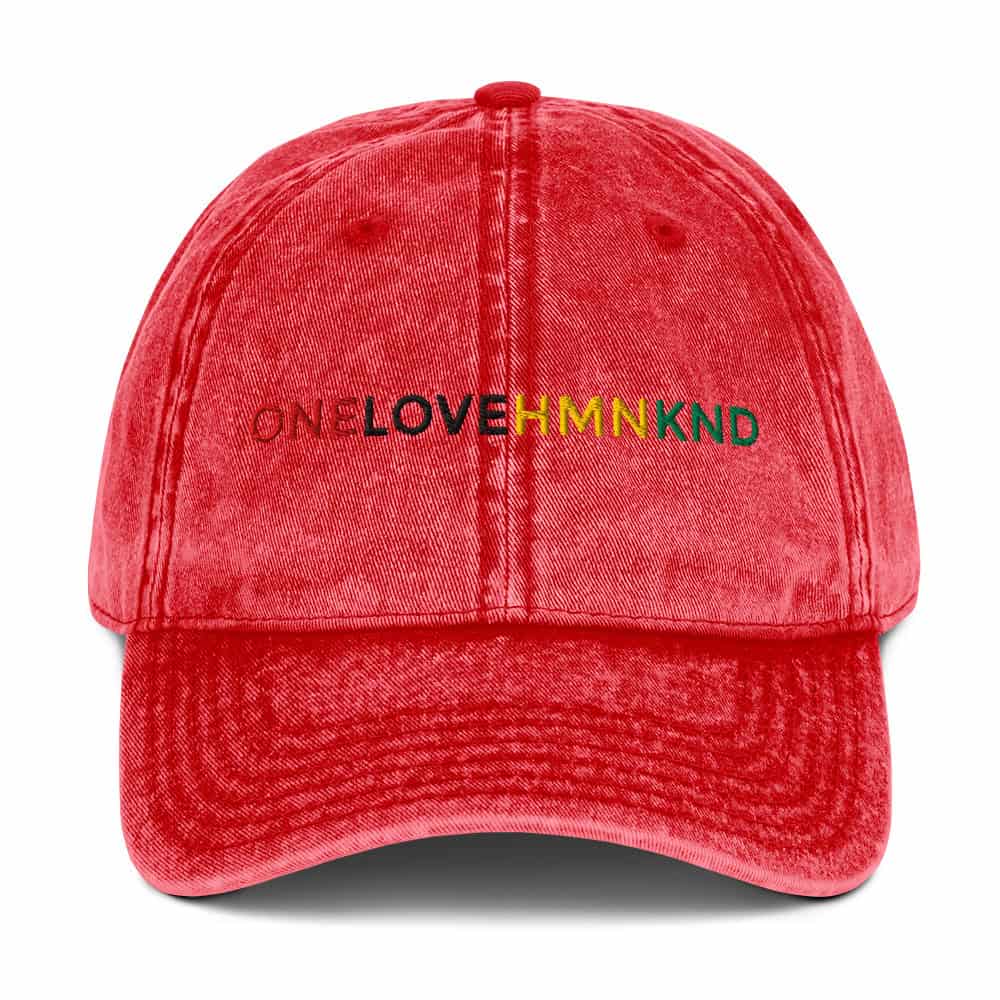 "Red denim baseball cap with colorful OneLoveHMNKND embroidery for inclusive fashion statement.".