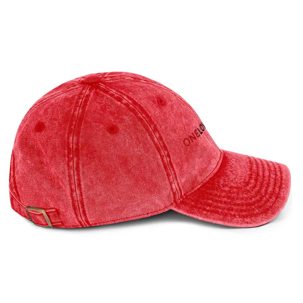 Red distressed baseball cap with embroidered "OneLove" logo, adjustable strap, stylish and durable.